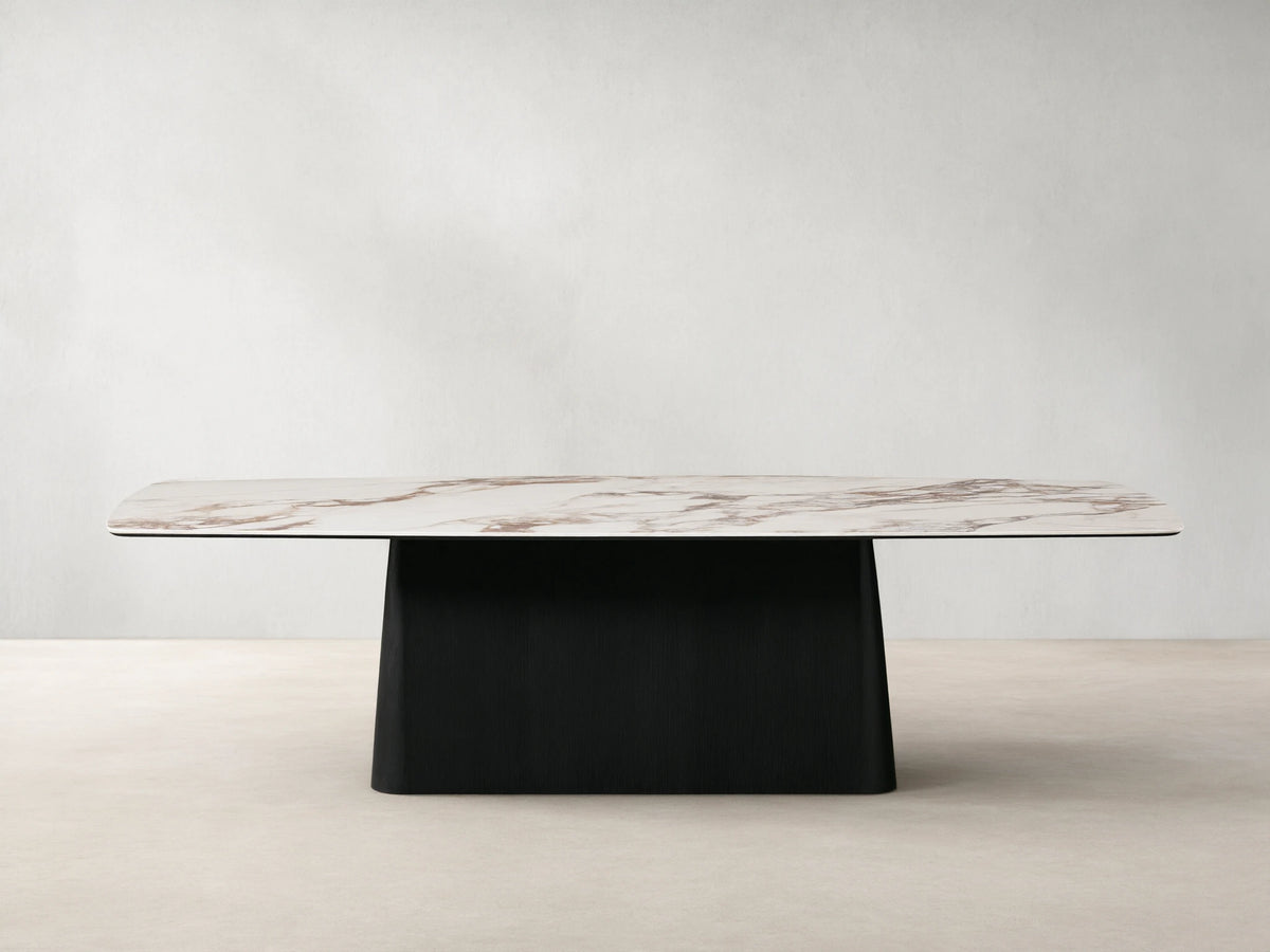 Vincenza Dining Table with calacatta marble-patterned ceramic top and solid wood Toulouse base, set on wooden floor.