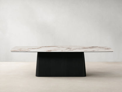 Vincenza Dining Table with calacatta marble-patterned ceramic top and solid wood Toulouse base, set on wooden floor.
