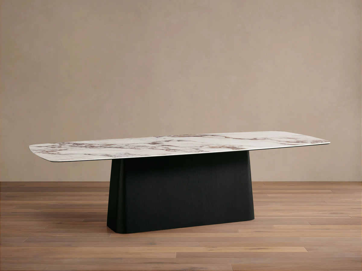 Vincenza Dining Table with calacatta marble-patterned ceramic top and solid wood Toulouse base, set on wooden floor.