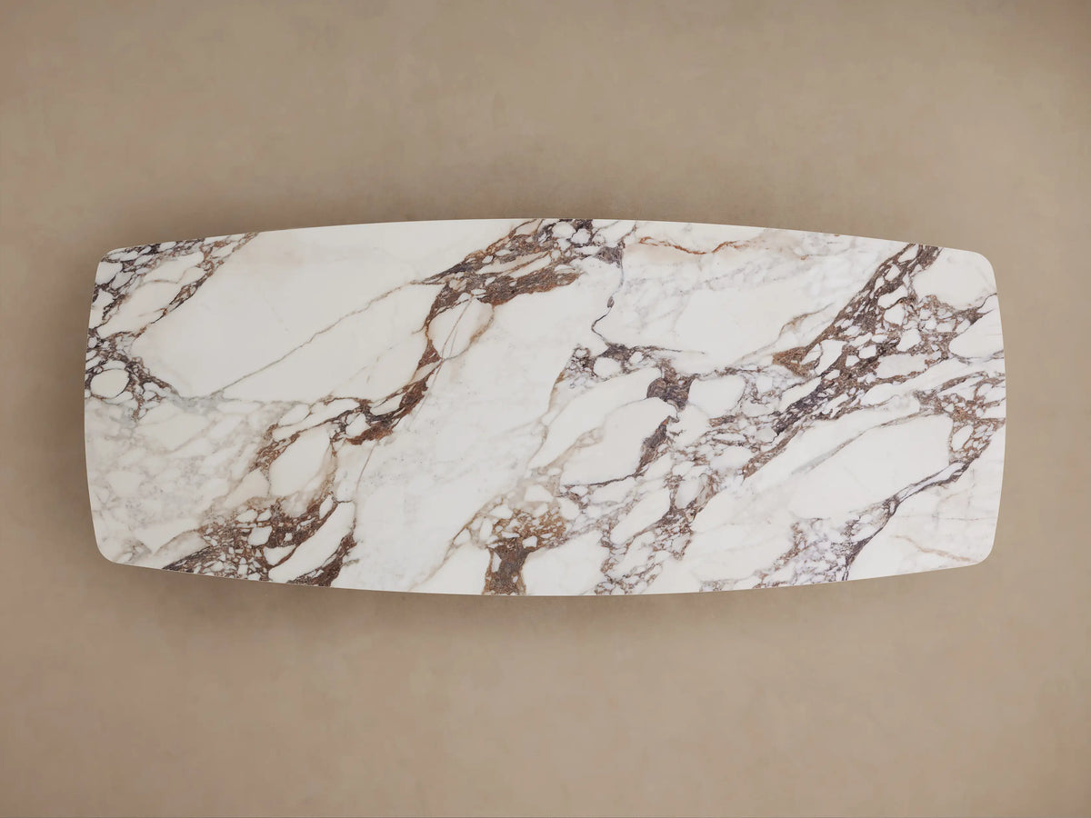 Vincenza Dining Table with a calacatta marble-patterned ceramic top on a thick, rectangular black Toulouse wood base.