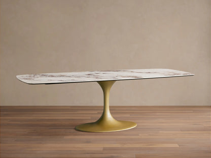 Vincenza Dining Table with ceramic calacatta marble-patterned rectangular top and gold steel pedestal base on wooden floor.