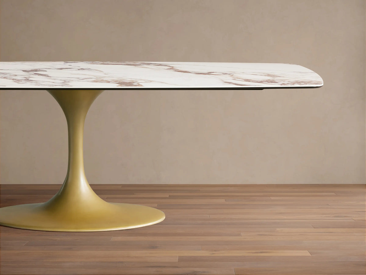 Vincenza Dining Table with ceramic top mimicking calacatta marble pattern, features a gold-colored steel base.