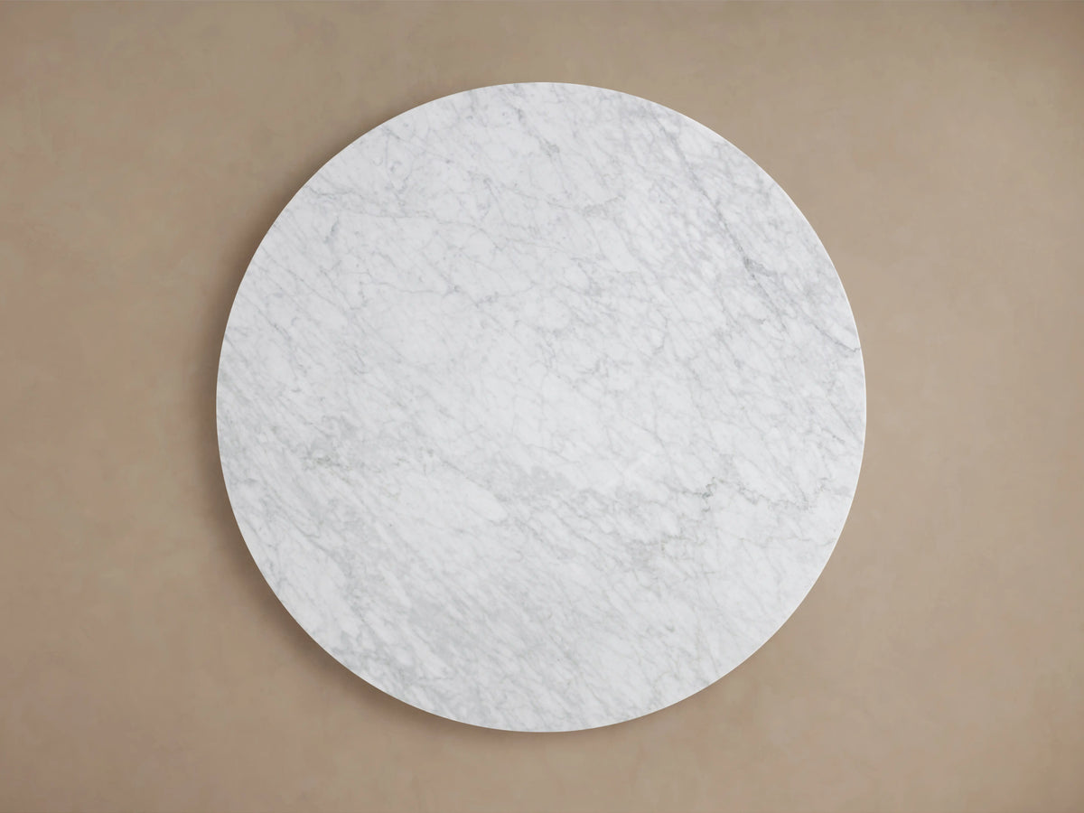 Top-down view of the Saint Germain round Carrara marble tabletop, white with grey veining, against a neutral beige background.