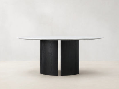 Saint Germain Round Stone Dining Table: White marble top resting on a black wood Dauphine base with two curved vertical segments.