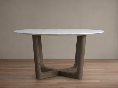 Saint Germain round dining table with white marble top and dark wood Rennes base on a wooden floor, against a beige wall.