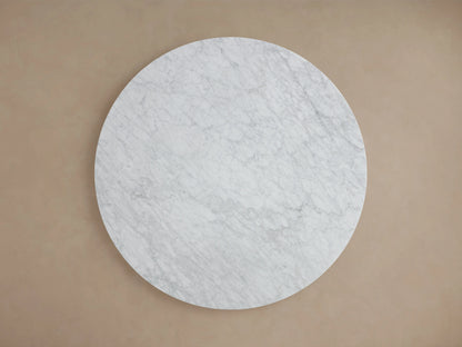 Round tabletop of the Saint Germain Dining Table in light gray Carrara marble with subtle veining, showcasing smooth polished edge.