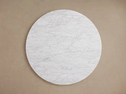 Round tabletop of the Saint Germain Dining Table in Carrara marble, featuring gray veining and a smooth, polished surface.