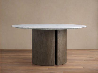 Round dining table with a white Carrara marble top and a sturdy brown oak veneered base. The marble surface shows subtle veining.