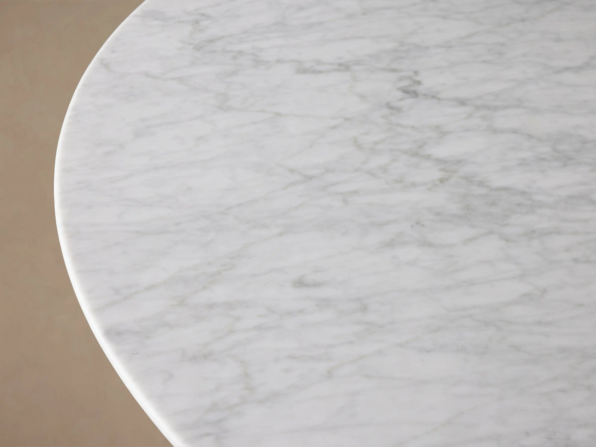 Front view of the White Carrara marble Saint Germain Round Stone Dining Table with Antique Brass Rennes Base in Metal.