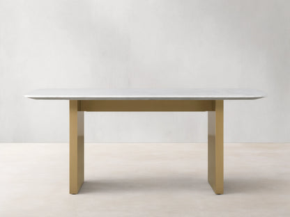 Saint Germain Stone Dining Table with a smooth white Carrara marble top on a sturdy, rectangular antique brass base.