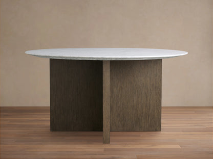 Saint Germain dining table with round white stone top and wooden base, set on a light wood floor against a neutral wall.