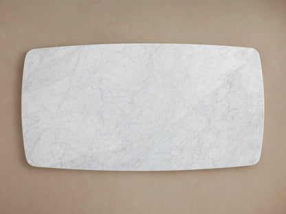 Close-up of the Saint Germain Dining Table's Carrara marble top, showing light gray veining against a white background, with rounded edges.