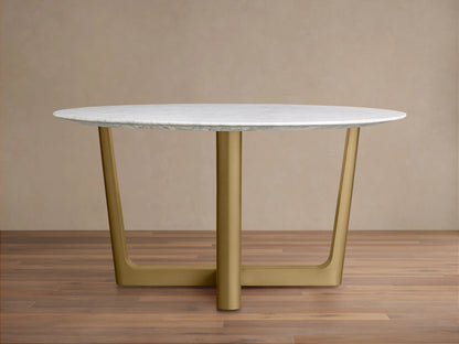 Saint Germain Round Stone Dining Table with a Carrara marble top and a Rennes base in chestnut finish, placed on a wooden floor.
