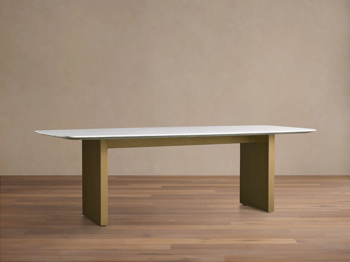 Front view of the Saint Germain 96" Stone Dining Table with Metal Clement Base, white stone top and brass bases.