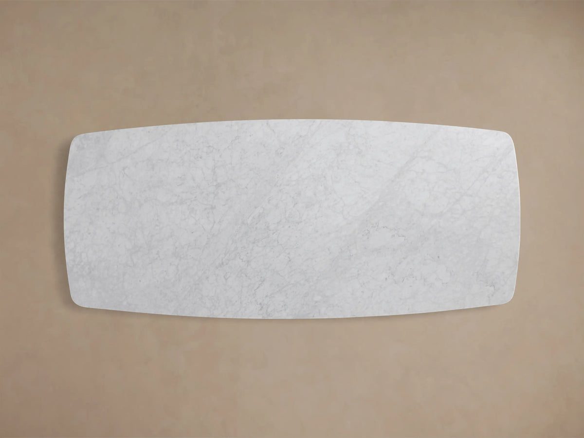 Close-up of the Carrara marble tabletop of the Saint Germain 96" Stone Dining Table with Metal Clement Base.