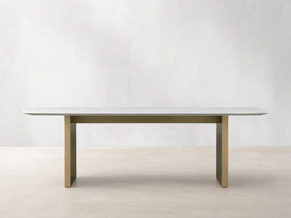 Front view of the Saint Germain 96" Stone Dining Table with Metal Clement Base, white stone top and brass bases.