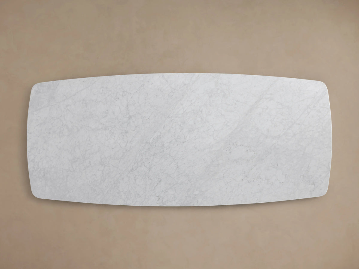 Close-up of a Saint Germain Dining Table’s corner, featuring white Carrara marble with subtle gray veining and a smooth, rounded edge.