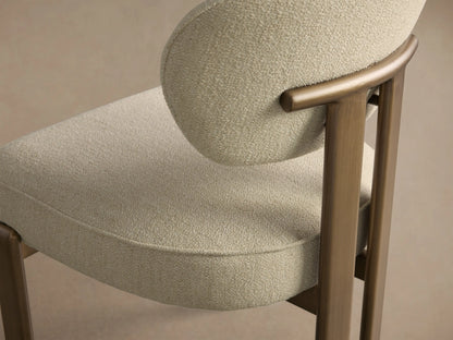 Front view of the Cea Dining Side Chair featuring a light cream upholstered seat and back, with an antique brass metal frame.