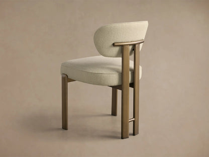 Close-up of the Cea Dining Side Chair with light beige textured upholstery and antique brass frame.