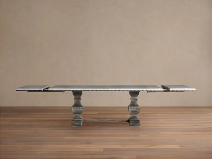 Cerea Amalfi Bell'Arte Dining Table: rectangular dark grey top with intricate patterned edge, two distressed grey pedestal legs.