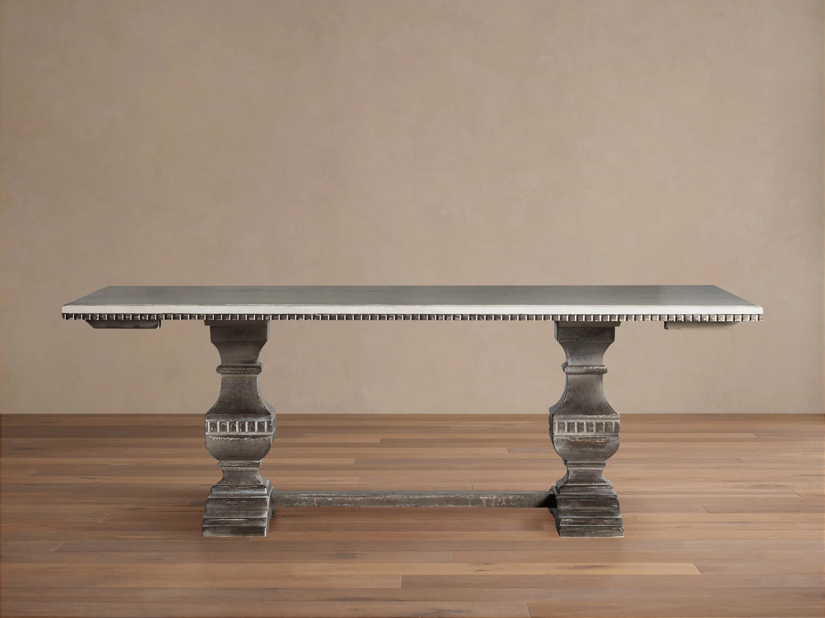 Cerea Amalfi Bell'Arte Dining Table with light gray top, dark distressed pedestal bases, and subtle hand-painted apron detail.