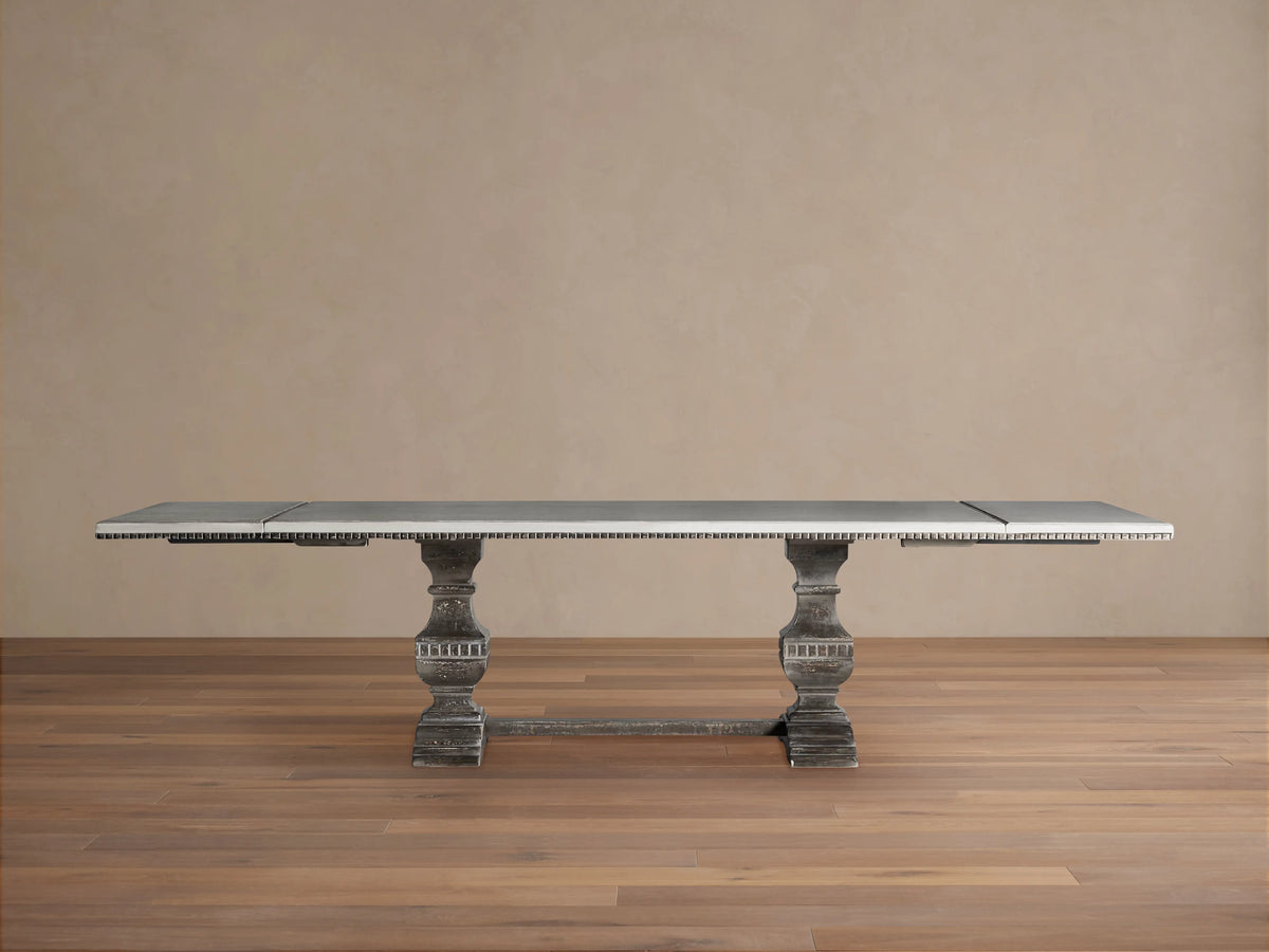 Cerea Amalfi Bell'Arte Dining Table with rectangular distressed light gray top and two ornate dark gray pedestal bases.