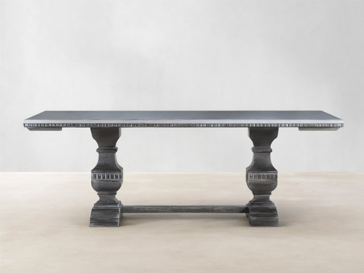 Cerea Amalfi Bell'Arte Dining Table with light gray top, dark distressed pedestal bases, and subtle hand-painted apron detail.