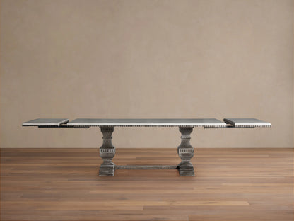 Cerea Amalfi Bell'Arte Dining Table with distressed dark grey pedestal base and light rectangular top with visible extensions.