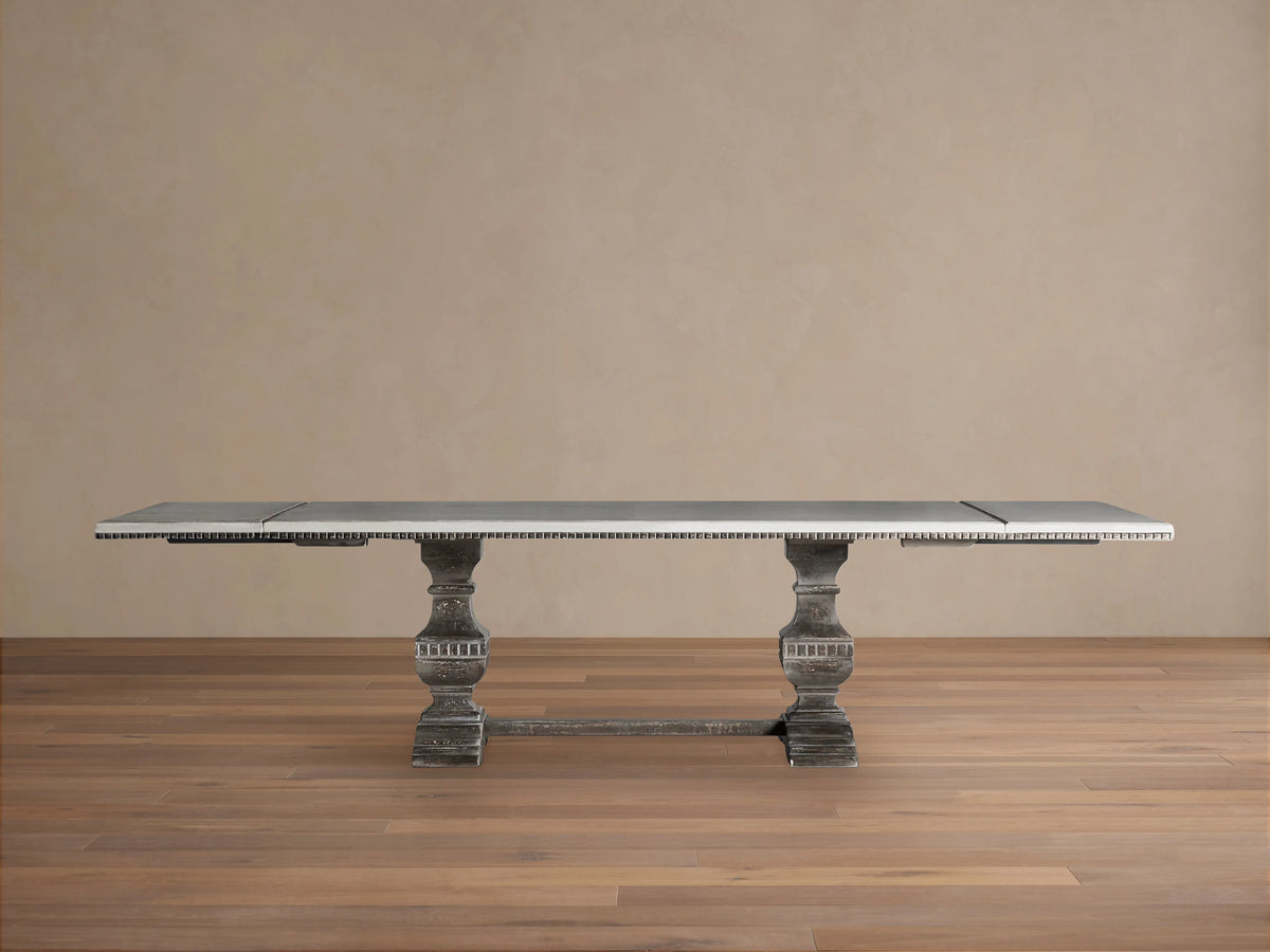 Cerea Amalfi Bell'Arte Dining Table. Dark distressed rectangular with ornate pedestal bases, light top, intricate painted trim.
