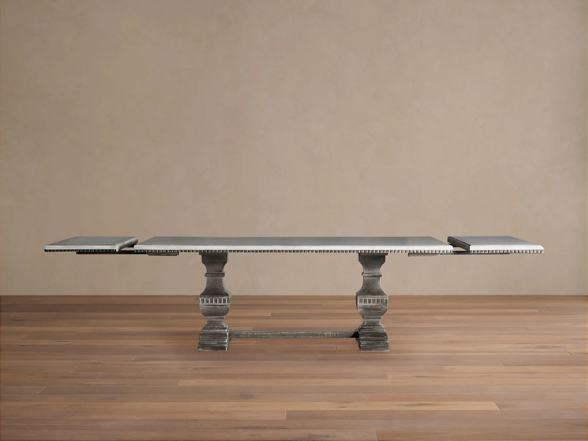 Cerea Amalfi Bell'Arte Dining Table, rustic, with a light gray, hand-painted distressed rectangular top and dark ornate pedestal base.
