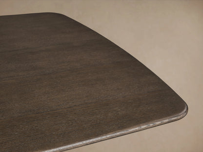 Saint Germain Wood Dining Table corner with an Ebony finish, showcasing solid oak grain and smooth rounded edges against a neutral background.