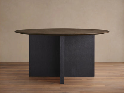 Round dining table with a dark wood top and an intersecting wood base, finished in a dark Ebony color, on a wood floor.