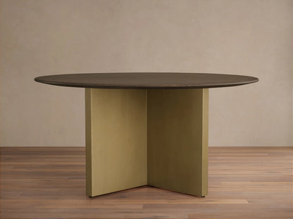 Round dining table with a solid oak chestnut finish top and a V-shaped antique brass steel base on a wooden floor.