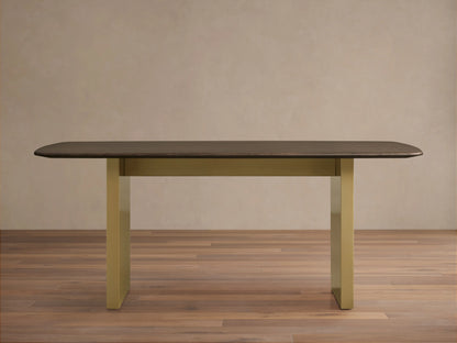 Wood dining table with a solid oak top in dark finish, supported by a rectangular base in antique brass. Placed on a wooden floor.