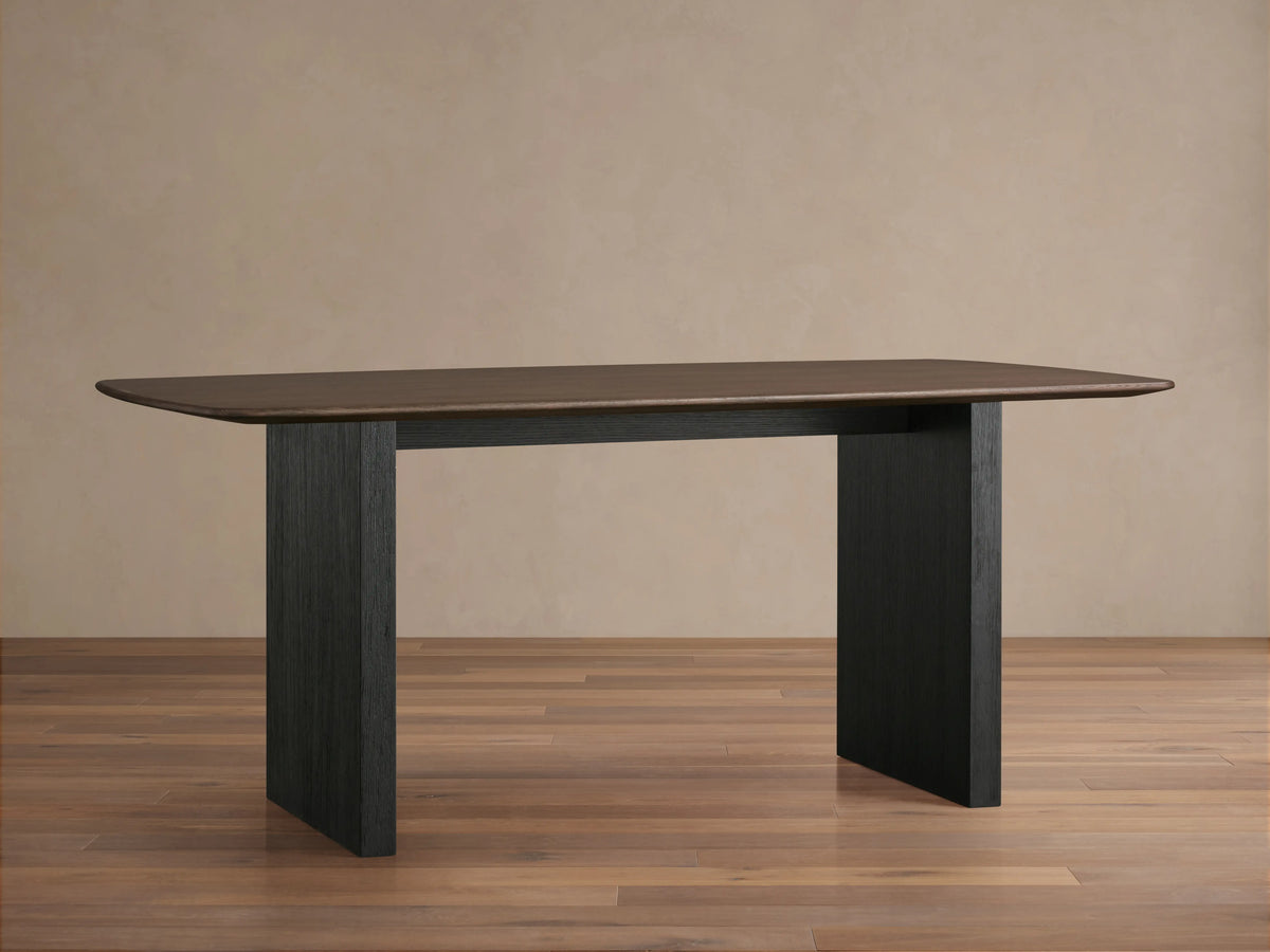 Rectangular Saint Germain Dining Table with solid oak top in dark finish, supported by wide ebony-finished veneer base.