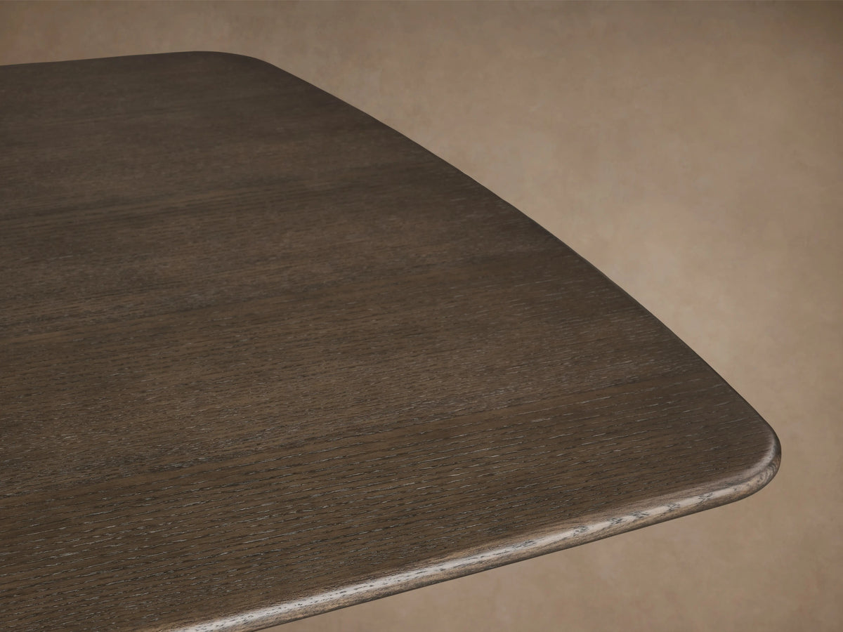 Saint Germain Wood Dining Table with rectangular top in dark finish, featuring two curved ebony bases on wooden floor.