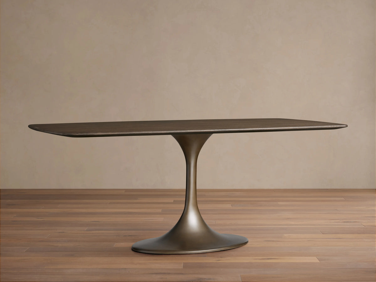 Saint Germain wood dining table with a rectangular solid oak top, dark finish, and a sleek, rounded steel base on wooden floor.
