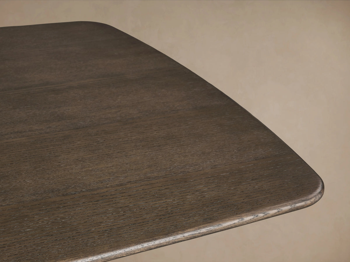 Saint Germain Wood Dining Table with solid oak top in dark finish; features elegant steel pedestal base on wooden floor.
