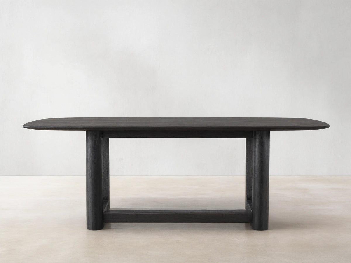 Saint Germain Wood Dining Table with a rectangular top in dark finish and sturdy, rectangular Rennes base on wooden floor.