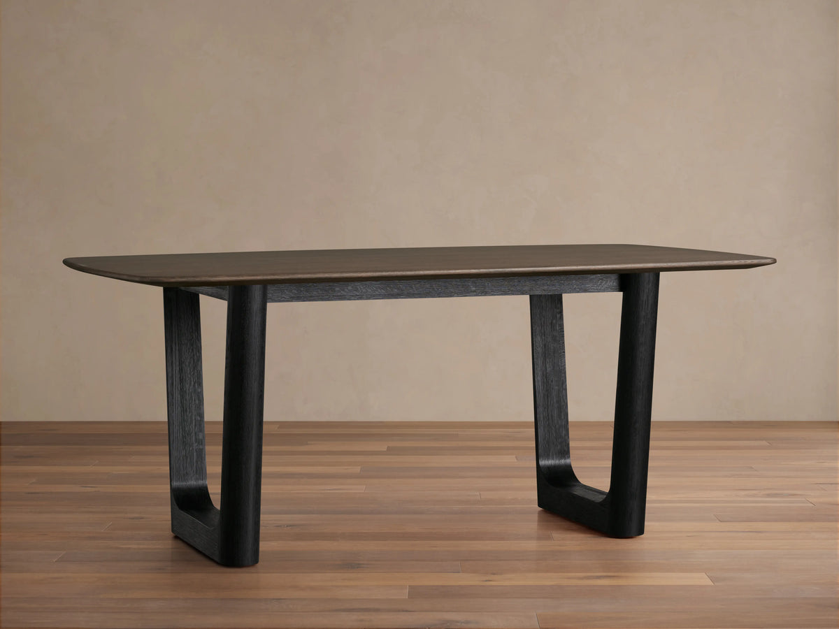 Saint Germain Wood Dining Table with a rectangular top in dark finish and sturdy, rectangular Rennes base on wooden floor.