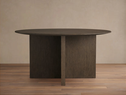 Saint Germain round dining table with a solid oak top and wood base, finished in chestnut. Set on a wooden floor.