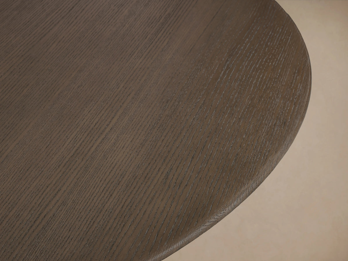 Saint Germain round dining table with solid oak top and wide wood Clement base, finished in dark chestnut on wooden floor.
