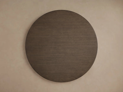 A detailed view of the Saint Germain Round Wood Dining Table's tabletop, showing the dark oak veneer with a smooth, rich chestnut finish.
