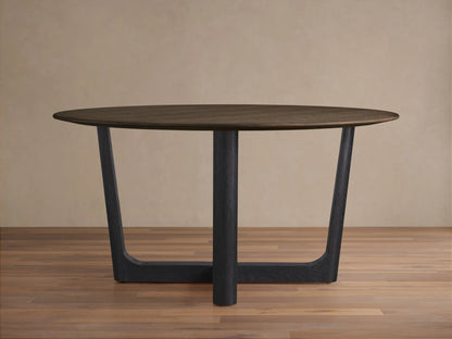 Saint Germain round dining table with dark wood top and ebony-finished Rennes base, set on light wood floor.