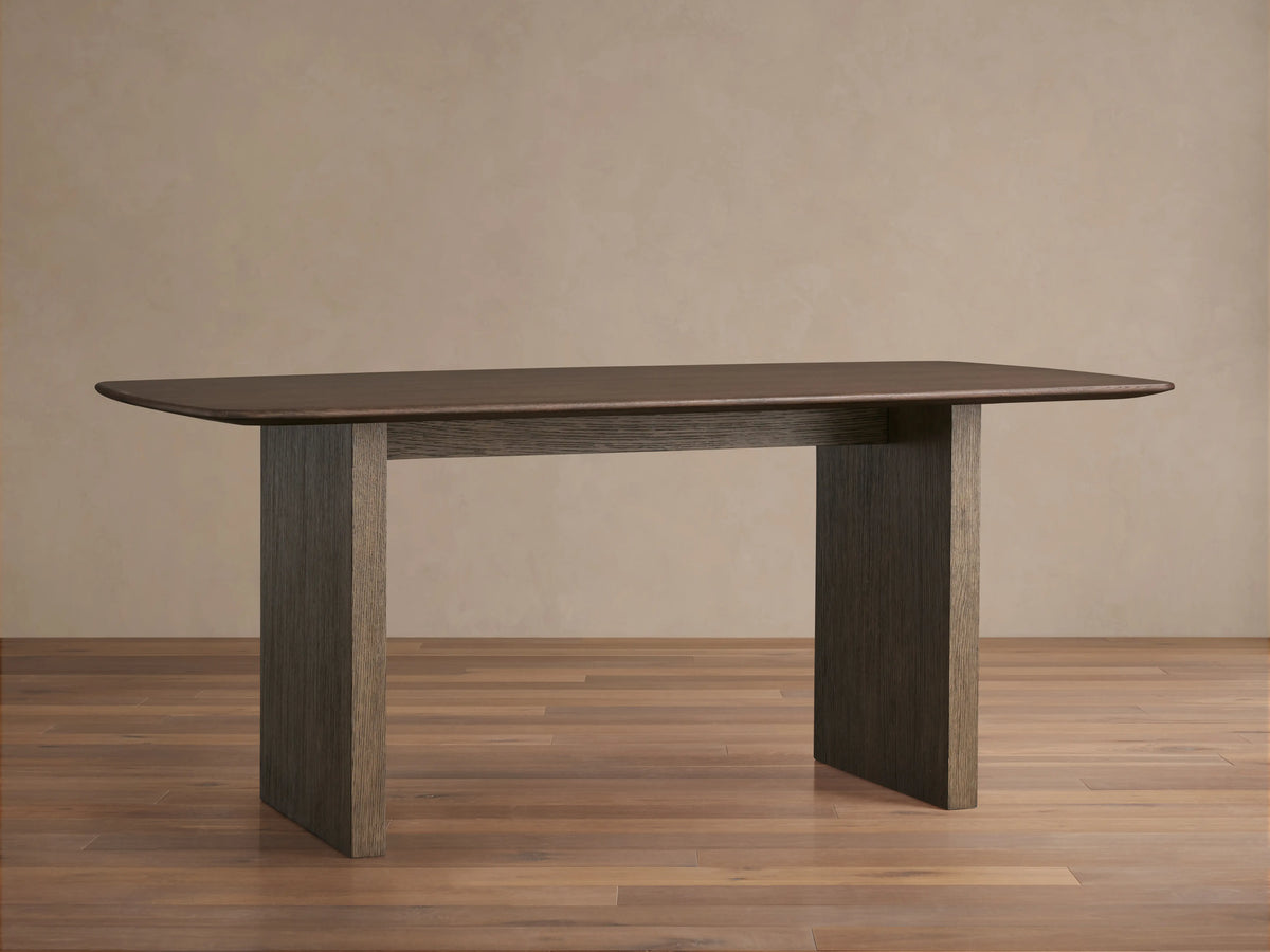 Saint Germain dining table with a rectangular solid oak top, dark finish, and sturdy wooden base on a wood floor.