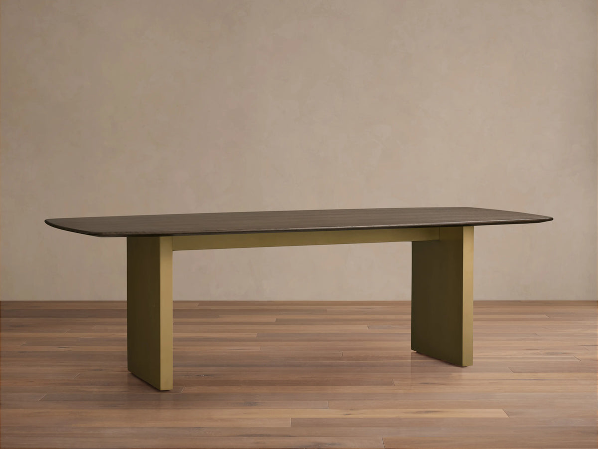 Saint Germain wood dining table with solid rectangular top in dark wood finish and thick rectangular legs in a light gold tone.