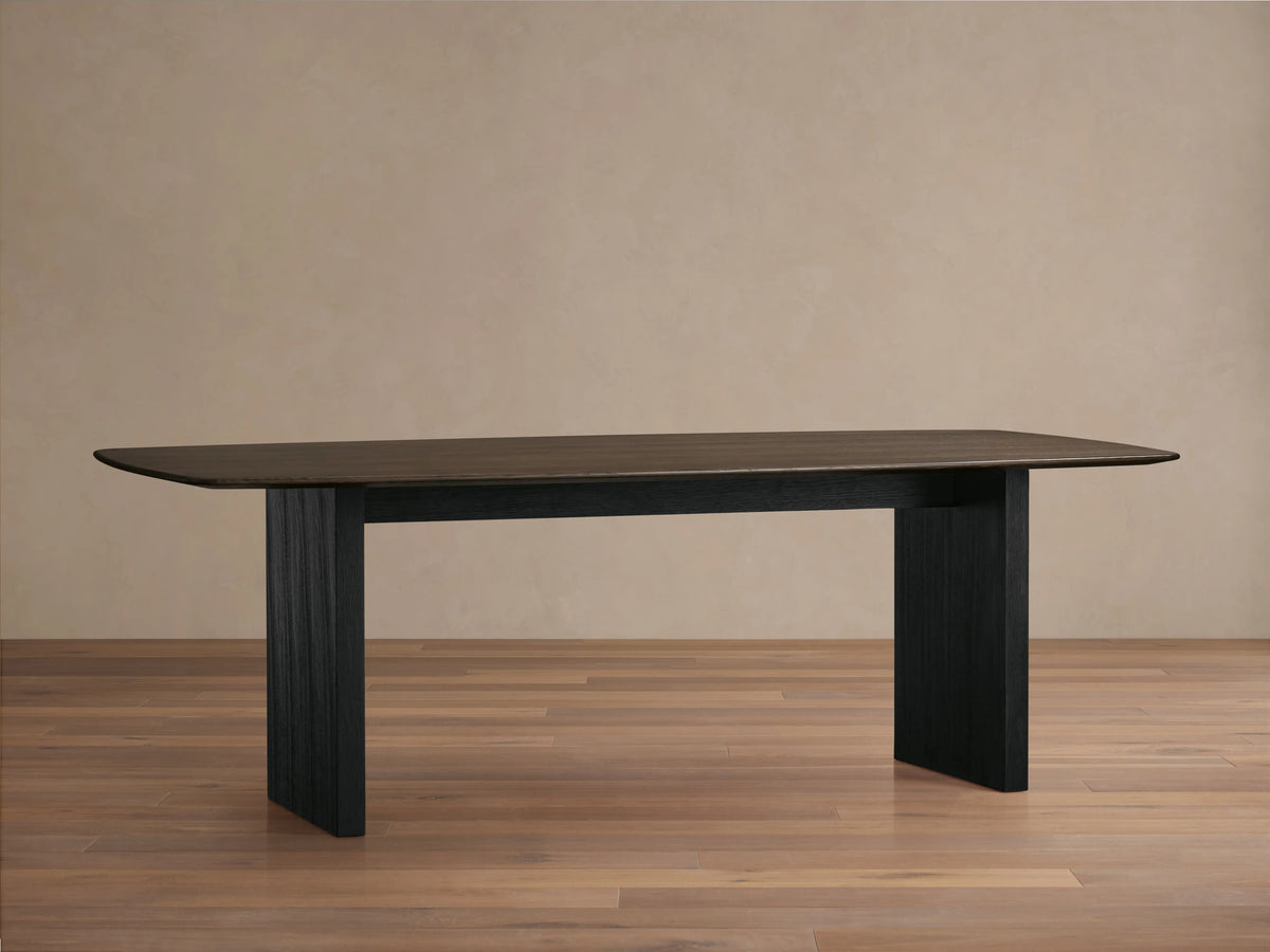 Saint Germain dining table with a solid oak top and ebony base. Rectangular shape, smooth surface, set on wooden floor.