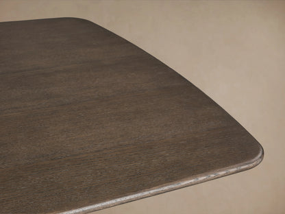 Saint Germain dining table with a dark wood top and two rectangular solid wood legs, set on a wooden floor background.