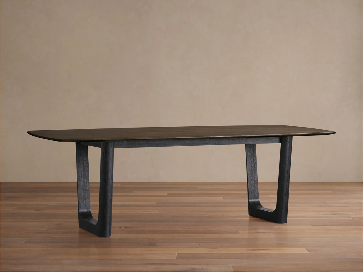 Saint Germain Wood Dining Table with rectangular solid oak top in dark finish, sleek edges, supported by sturdy wide legs.