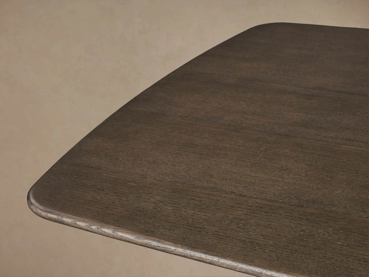 Saint Germain Wood Dining Table. Dark, rectangular tabletop with rounded corners, on a thick, tapered natural wood Toulouse base.